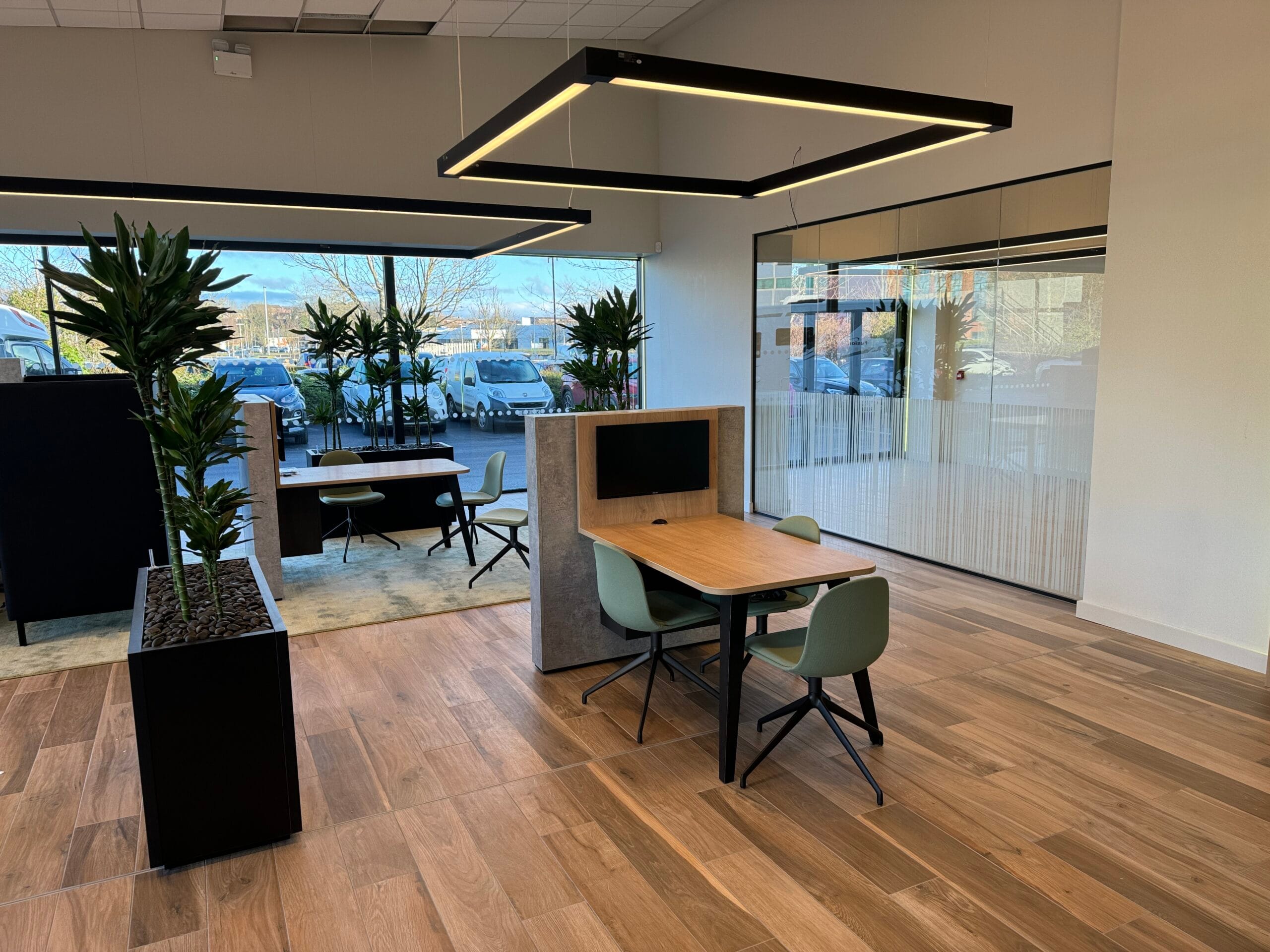 Modern office space with desks and plants.