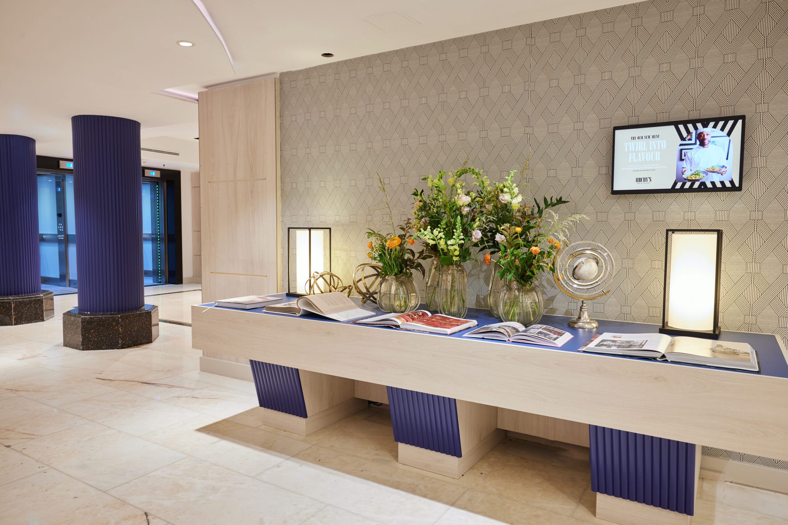Hotel side table with magazines and flowers on top