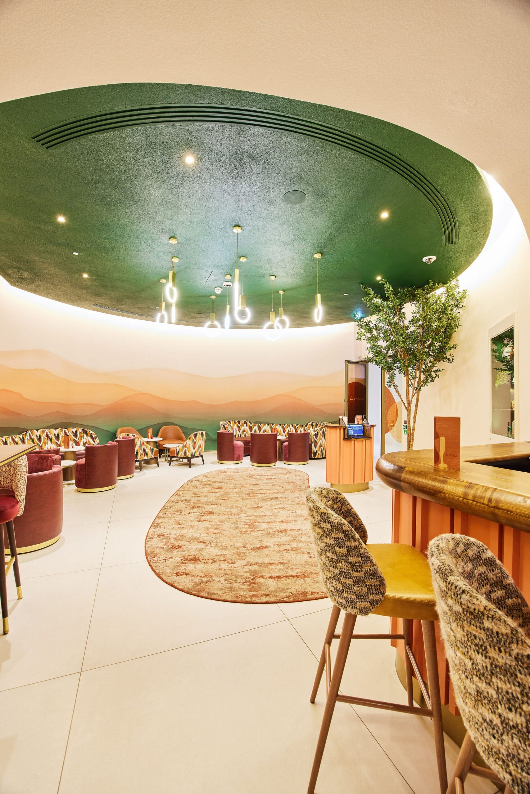 Modern lounge with colourful seating and green ceiling