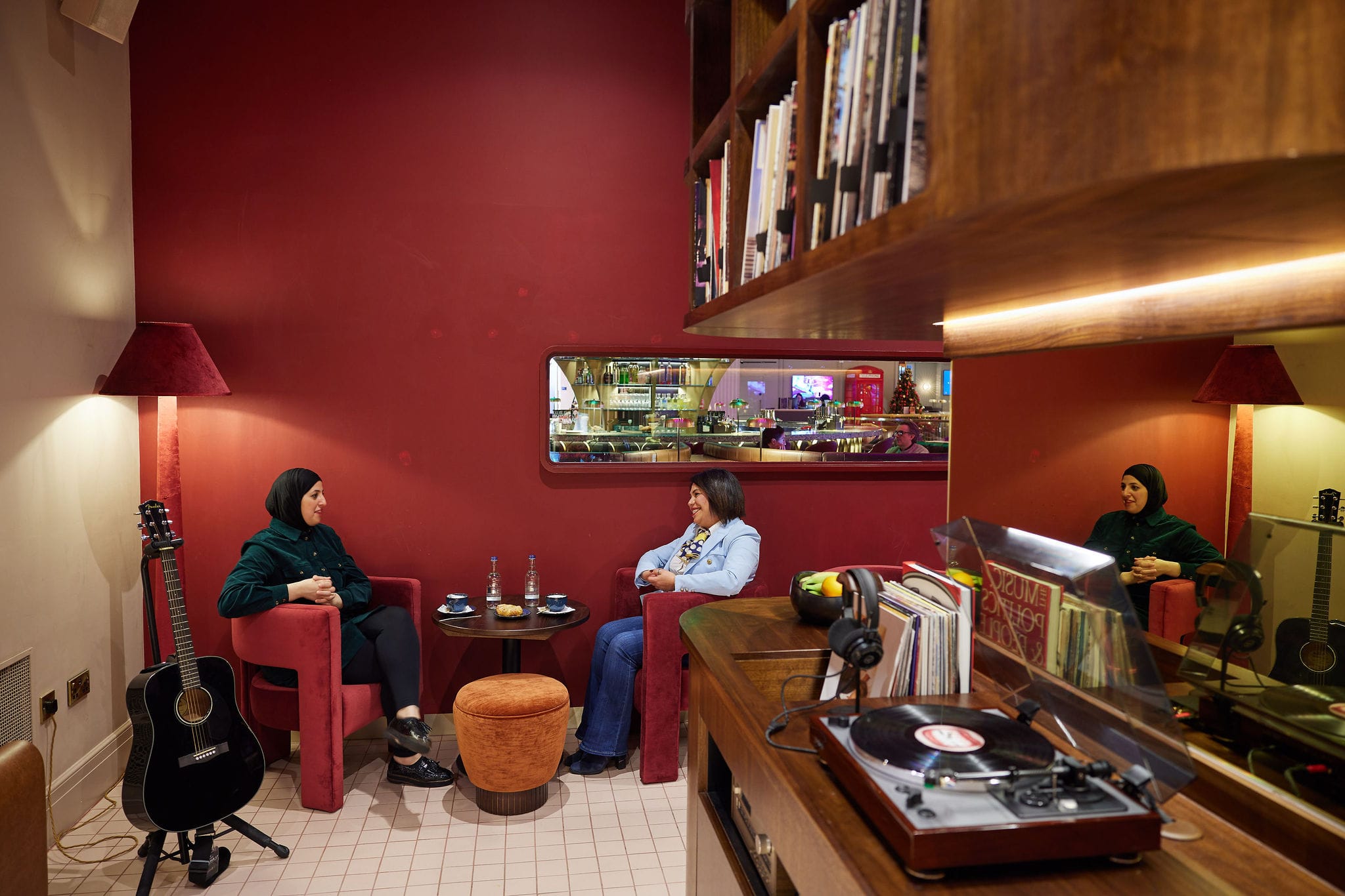 Two women chatting in cosy cafe lounge