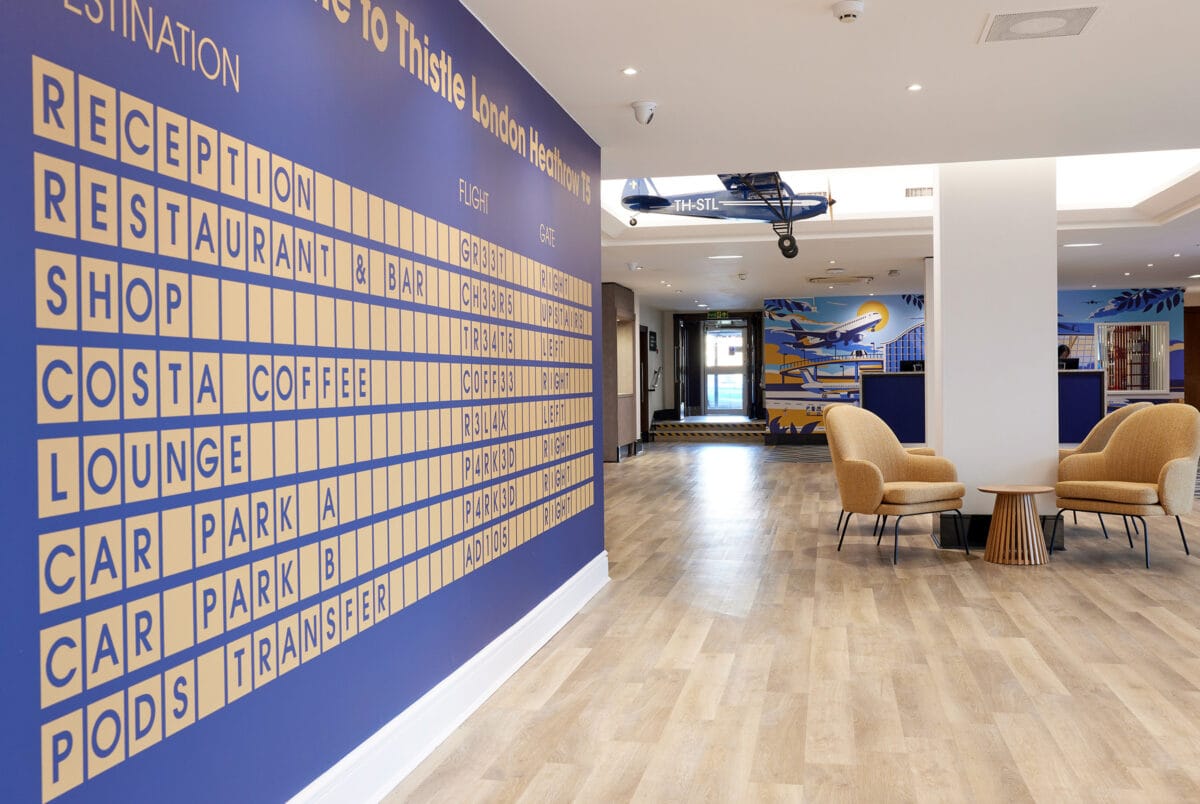 Airport-themed hotel lobby with departure board wall